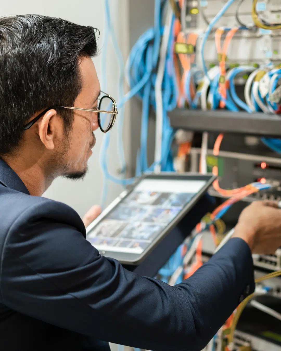 PCe Solutions Calgary network technician managing server room cabling with a tablet