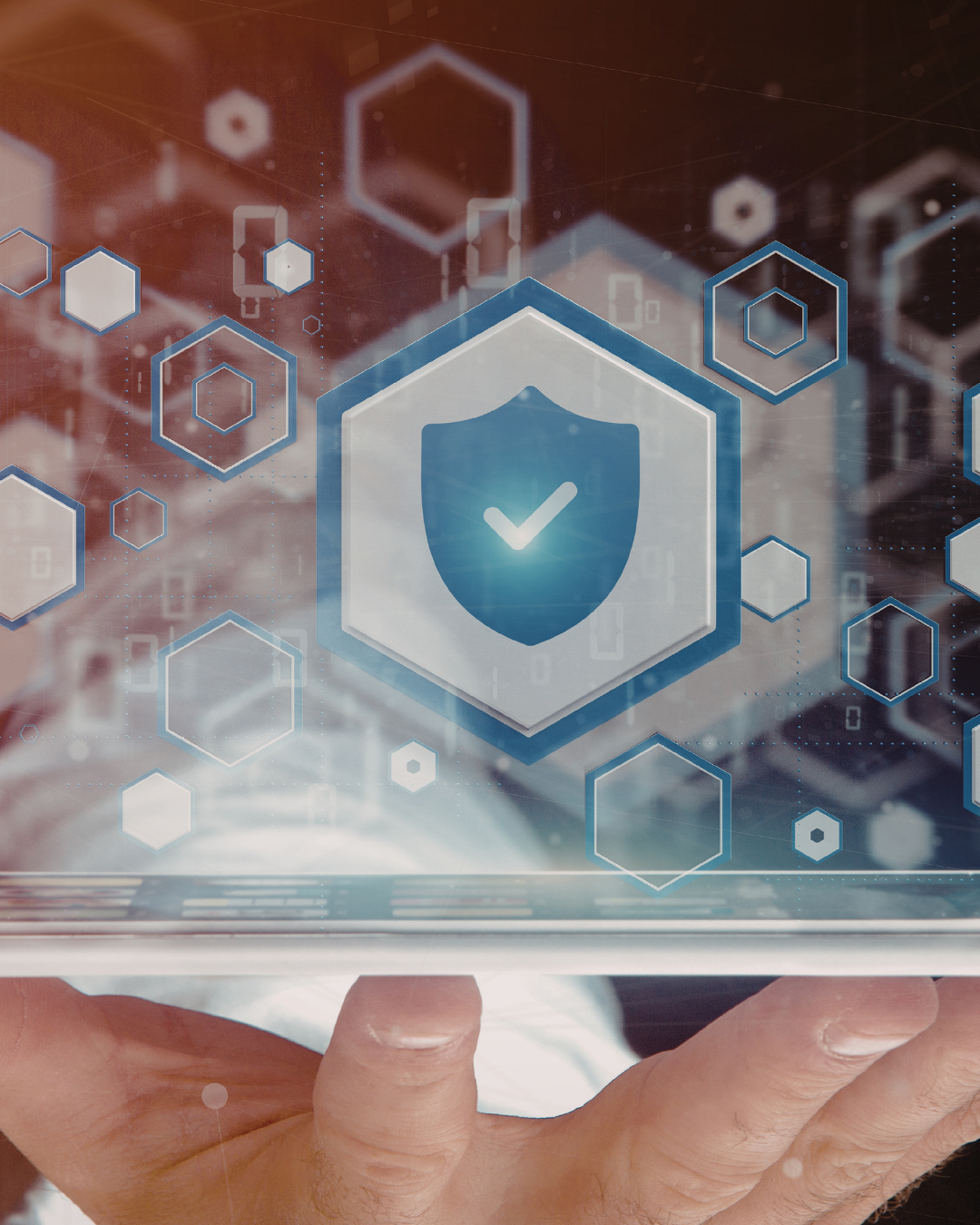 Person holding tech with shield graphic above it.