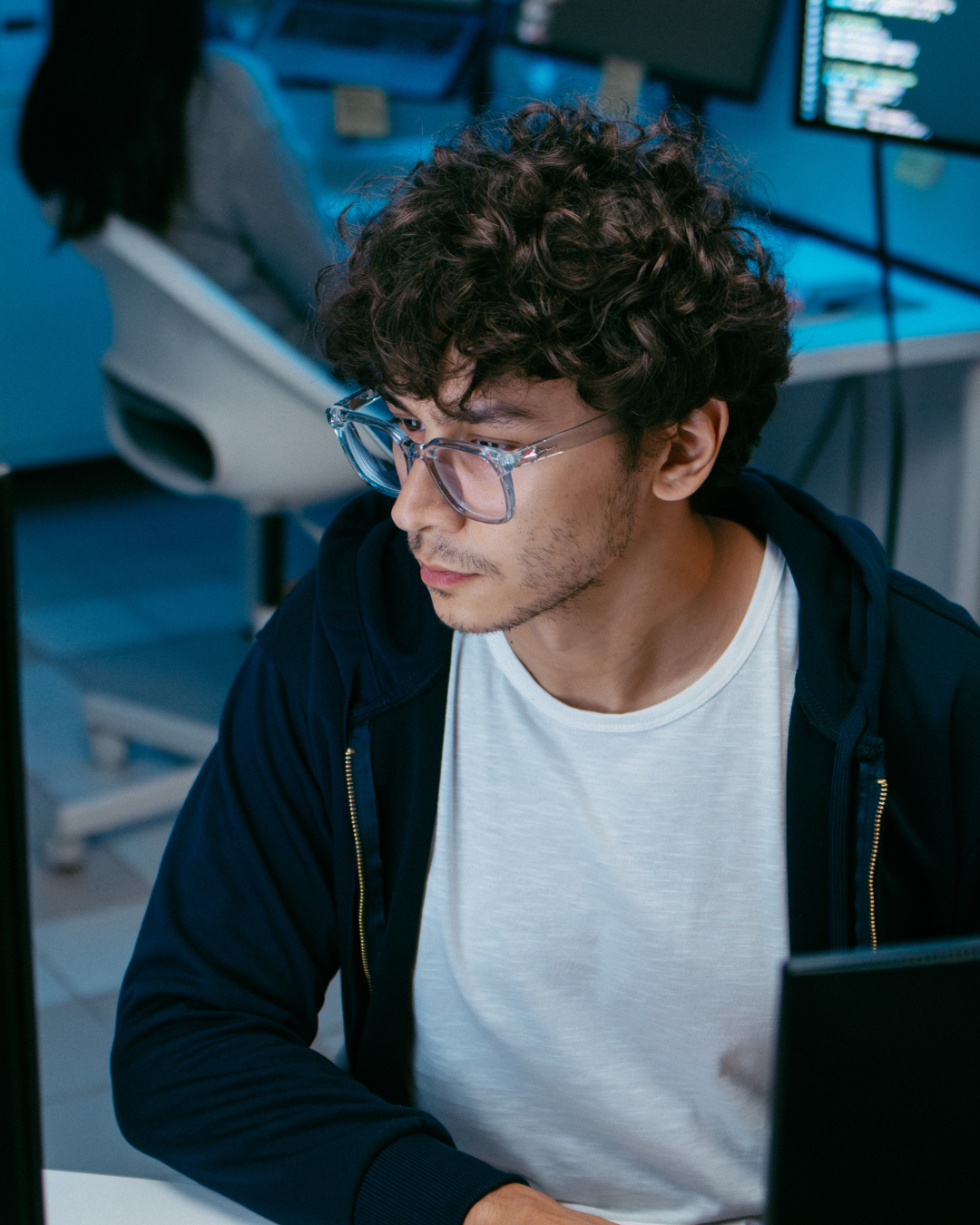 man wearing glasses looking at computer.