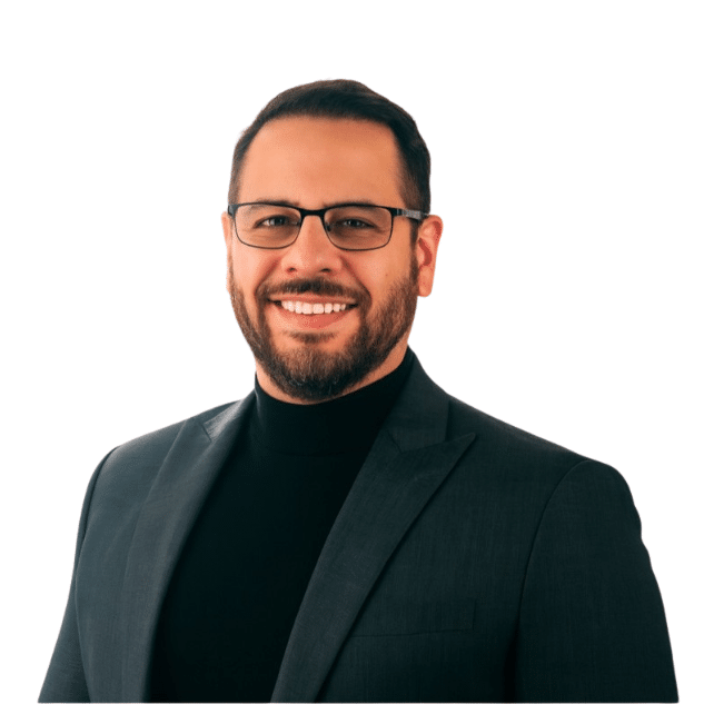 Photo of Peter Perez he is wearing a green suit with a black shirt. Our Mission