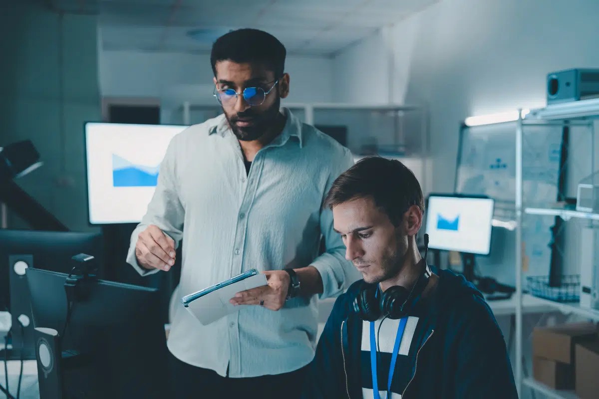 PCe Solutions Calgary cybersecurity IT team reviewing security analytics and threat data on tablet and monitors providing managed cybersecurity defense services to Calgary small businesses across Alberta
