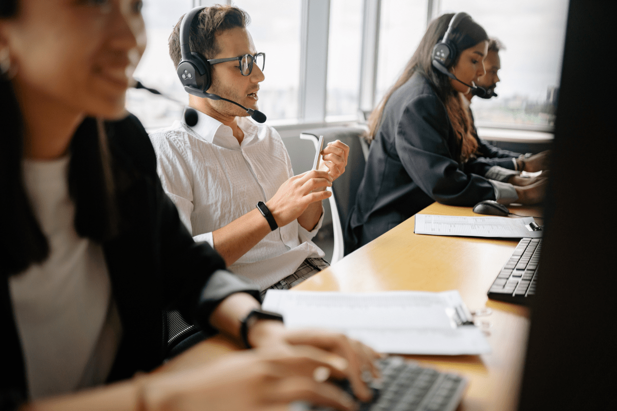 Calgary business team collaborating in a modern office huddle room using unified communications technology representing PCe Solutions VoIP and Microsoft Teams deployment services for Calgary Alberta organizations